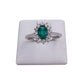 anello con smeraldo e diamanti bianchi a contorno. anello oro bianco 18 carati. stile classico